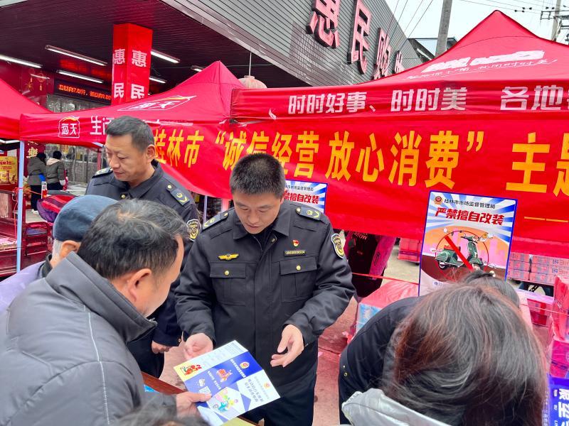 桂林市市场监管局送电动自行车安全科普走基层_广西桂林市市场监管局工作人员为群众答疑解惑，并发放安全消费电动自行车宣传资料_123a8b52aa0a49d49d9cdd3751900c65.jpg