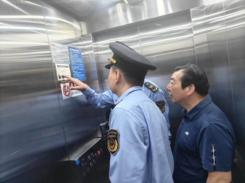 河南省许昌市市场监督管理局魏都区分局五一节前大检查为消费者护航_执法人员在检查酒店电梯1.jpg_a2f5d7dee33b4520804ddcd49b6e5ffb.jpg