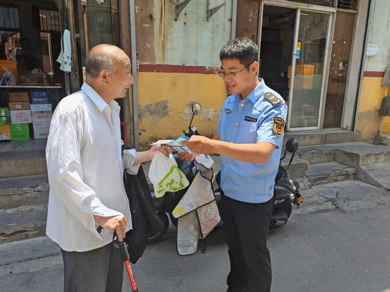 河南省许昌市市场监督管理局魏都区分局开展“守住钱袋子，护好幸福家”防范非法金融宣传月活动_工作人员细心的为老年人进行宣讲.jpg_cd632e9d44004f4cb7db0fc959548e36.jpg